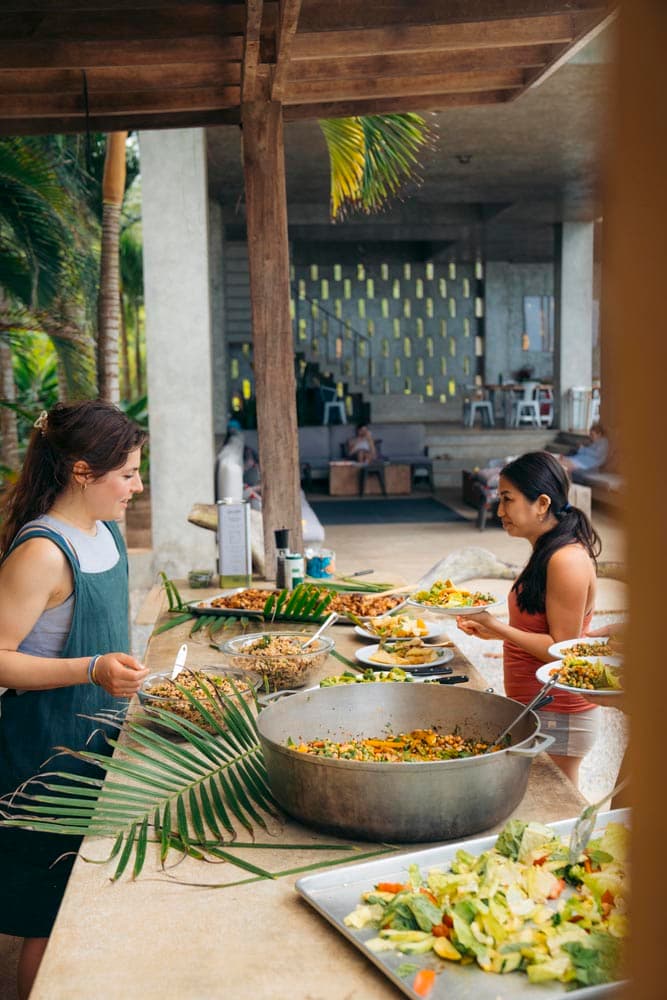 Guests serving themselves from a fresh buffet lunch in an open-air pavilion